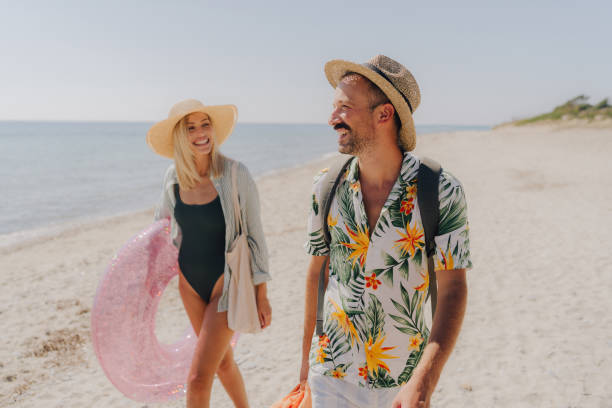 istock Smiling couple arriving at the beach 2197768250