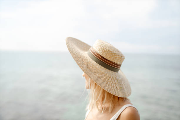 Photo of a smiling woman enjoying a day at the beach.