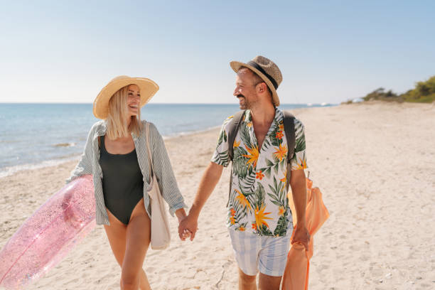 istock Smiling couple arriving at the beach 2197768303