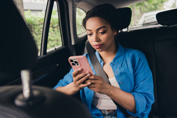 istock Young woman using smartphone while traveling in car, looking engaged and relaxed during urban journey 2197768753