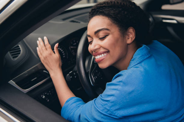 istock Joyful young woman inside a vehicle, embracing the steering wheel with a cheerful expression, enjoying the thrill of driving 2197768807