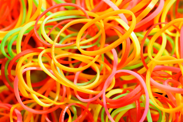 Vibrant collection of colorful rubber bands creates a playful and abstract background. Ideal for projects related to creativity, organization, or office supplies.