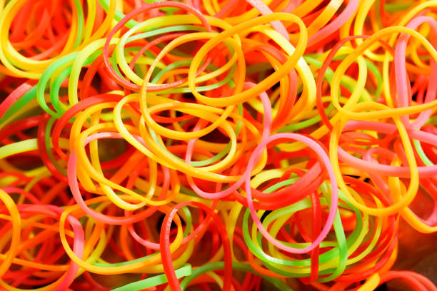 A vibrant collection of colorful rubber bands creates a lively and chaotic composition, showcasing vibrant red, yellow, and green textures perfect for various organizational and creative uses.