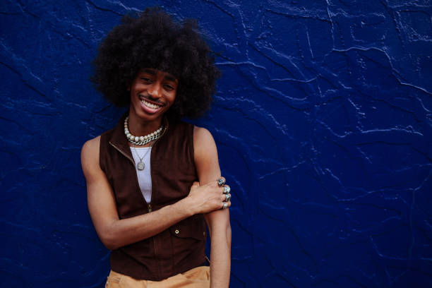 istock Young man with afro hair smiling near a blue wall 2197789547