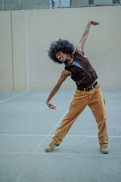 istock Young man with afro hair dancing in urban environment 2197789552