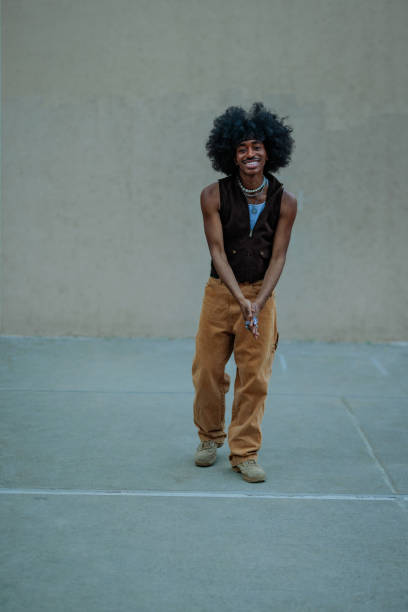 istock Young man with afro hair smiling and looking at camera 2197789564