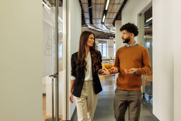 istock Businesspeople walking and talking in office corridor 2197789610