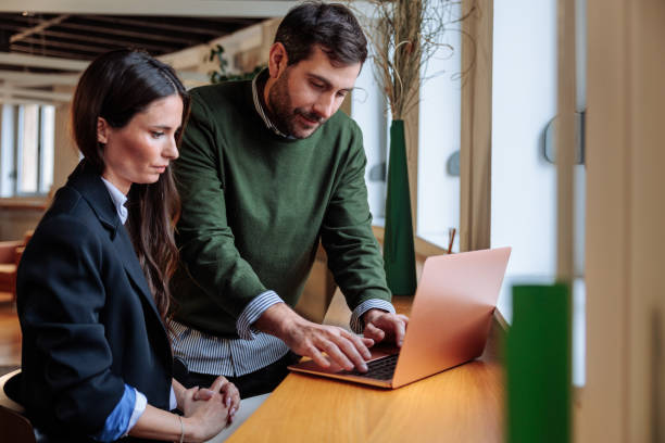 istock Coworkers using laptop in the office are looking down 2197789646