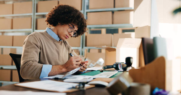 istock Man, writing and paperwork for distribution industry, inventory update and logistics information. Male person, documents and ecommerce schedule with stock checklist, supply chain and order feedback 2197790632