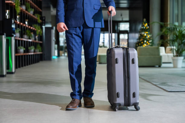 istock Man in blue suit standing with a big suitcase 2197791351