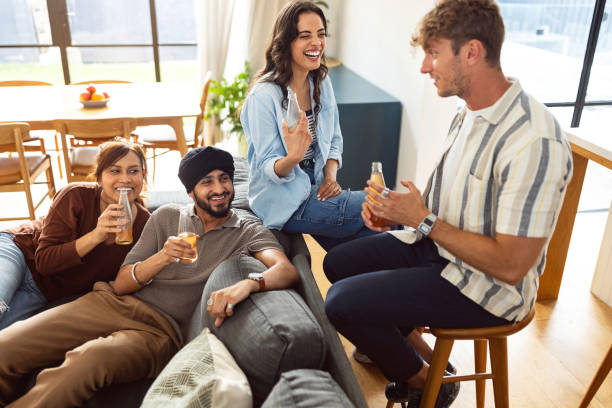 istock Young Friends Enjoying Drinks and Laughing Together at a Home Gathering 2197792976