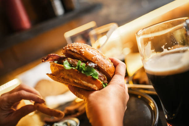 istock Woman eating burger in a cafe or pub 2197794045