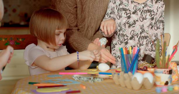 istock Easter eggs painting. Family gathers around the table, preparing for Easter 2197799980