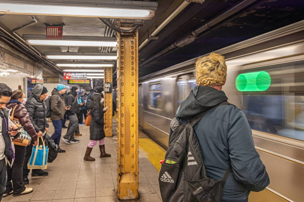 New York Subway, Lexington Avenue, Manhattan, New York, United States - January 9th 2025:  People in winter clothes waiting for the arriving subway train at the underground station