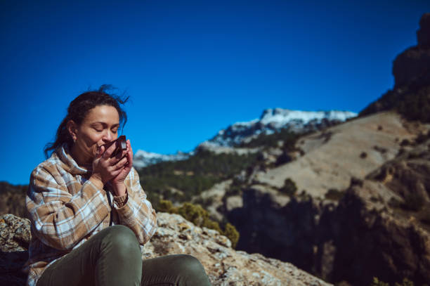 istock Woman enjoying a warm drink while appreciating a scenic mountain view on a sunny day 2197802196