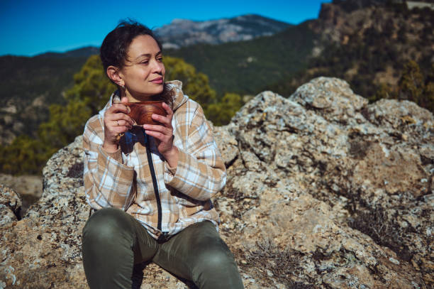 istock Woman Enjoying a Warm Drink Outdoors During a Scenic Mountain Adventure 2197802899