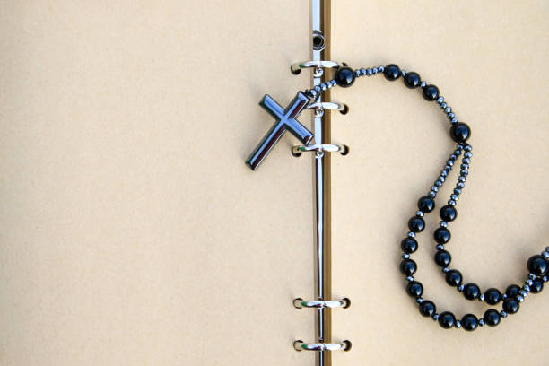 A shiny metal cross rests on an open brown notebook, symbolizing faith, reflection, and devotion. This image represents spiritual journaling, personal prayers, and religious contemplation.
