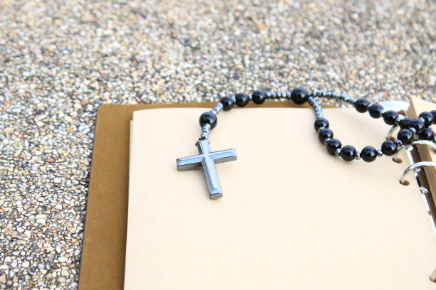 istock A shiny metal cross rests on an open brown notebook, symbolizing faith, reflection, and devotion. This image represents spiritual journaling, personal prayers, and religious contemplation. 2197803035