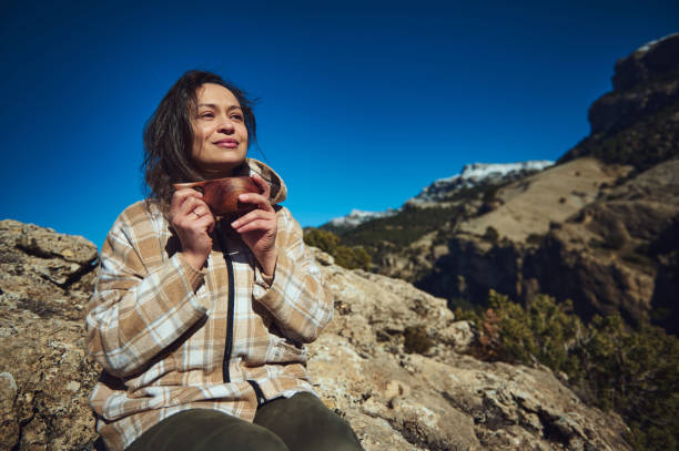 istock Woman enjoying nature while holding a warm beverage in the mountains 2197803094