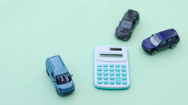 istock Small car models sit next to a calculator, symbolizing financial planning, insurance, budgeting, and car ownership. It represents vehicle costs, loans, and responsible investment. 2197804238