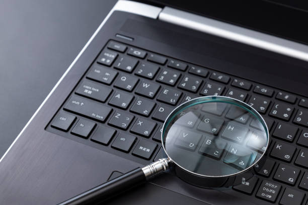 istock Laptop and magnifying glass on a black background 2197805438