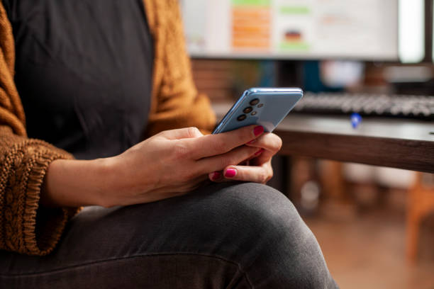 istock Female employee holding mobile device 2197806334