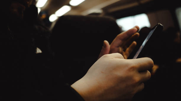 A young man with a beard and short dark hair sits on a train, traveling to Brussels, Belgium. He wears glasses, a black puffer jacket, and a patterned shirt, gazing out the rain-speckled window with a thoughtful expression. The blurred countryside outside and the dim, overcast weather create a moody, introspective atmosphere. The warm lighting inside the train contrasts with the cold, rainy day, adding to the feeling of isolation. His expression suggests deep contemplation, perhaps reflecting on stress, depression, or the desire to escape life for a moment. As he journeys to explore the city's architecture and culture, he seems lost in thought, caught between the weight of his emotions and the anticipation of something new.