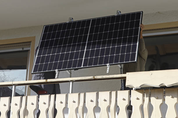 istock Two men assemble a balcony power plant to generate electricity 2197807112