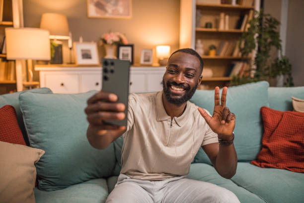 istock Smiling black man using smartphone to take selfie photos 2197807222