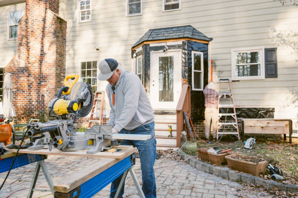 istock Construction workers repairing the siding of a house 2197809124