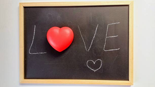 istock White background. Red heart on black chalkboard. Valentine's day. 2197809673