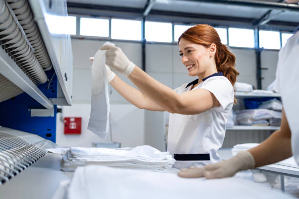 istock Dry cleaning service. Folding clean laundry and preparing for packing. 2197814812