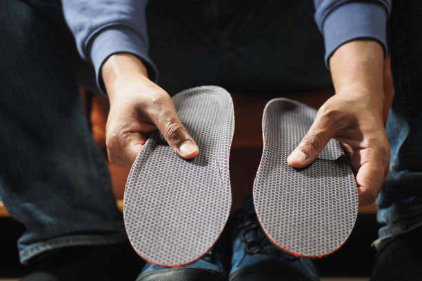 istock man hand putting Orthopedic insoles in shoes 2197816788