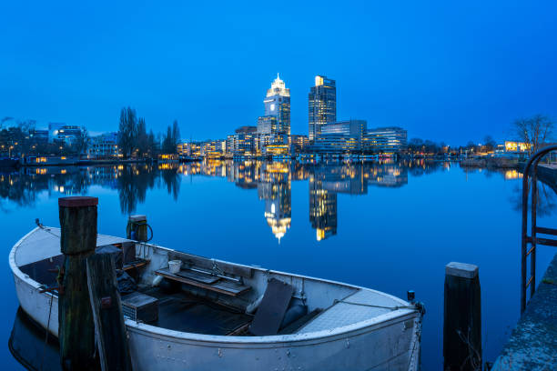 istock Modern office buildings in Amsterdam mirrored in Amstel river after sunset 2197819655