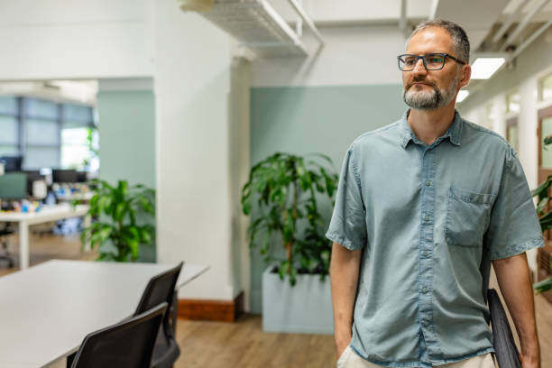 istock Professional man standing in a modern office space in Sydney, Australia, reflecting on work-related ideas 2197821676