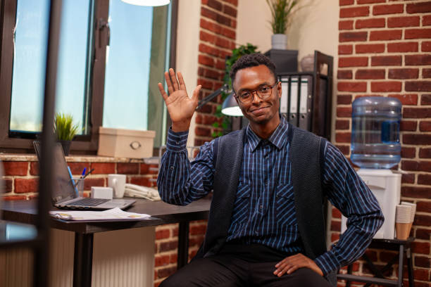 istock Black businessman waving hello to camera 2197825984