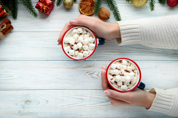 istock Female hands holding cappuccino with marshmallow in mugs 2197827254