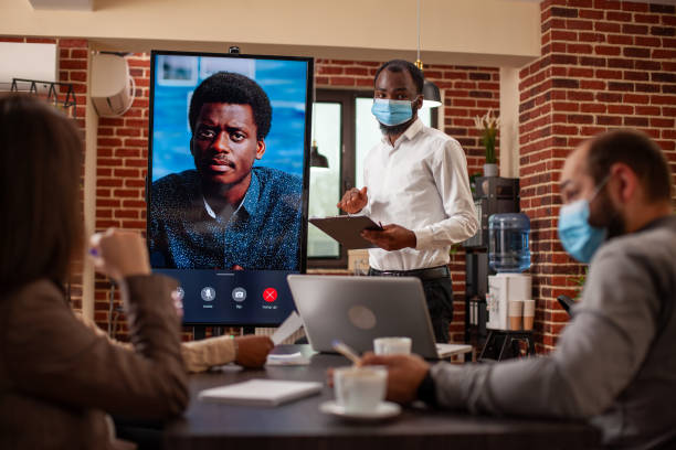 istock Masked coworkers discuss business project 2197827294