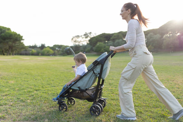 istock Mother pushing toddler son in stroller through park 2197830090