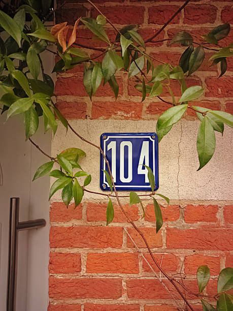 istock House number one hundred and twelve. against a uniform gray surface and a large crack 2197830443