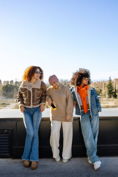 istock Three young women leaning on a wall and enjoying a sunny day, sky copyspace 2197832263