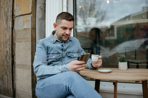 istock Man uses a mobile phone in a cafe 2197833862