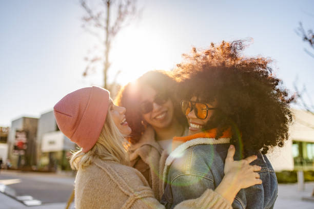 istock Three friends laughing together outdoors in bright sunlight 2197834272