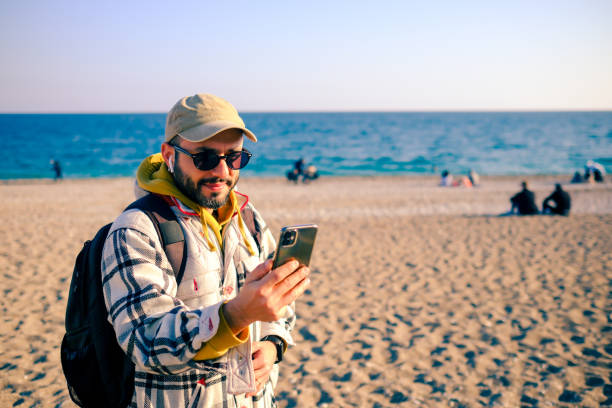 istock Young man making a video call on the beach 2197834776