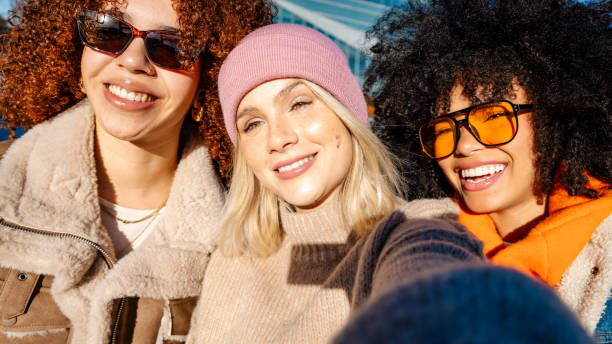 istock Three friends smiling and taking a selfie with a smartphone 2197835703