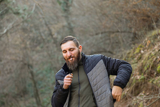 istock He drinks his beer and smokes a cigarette in nature by the river. 2197839379
