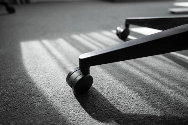 Black office chair wheel on carpet.