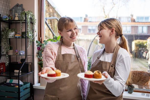 istock Two blonde teenage sisters making a cake 2197845568