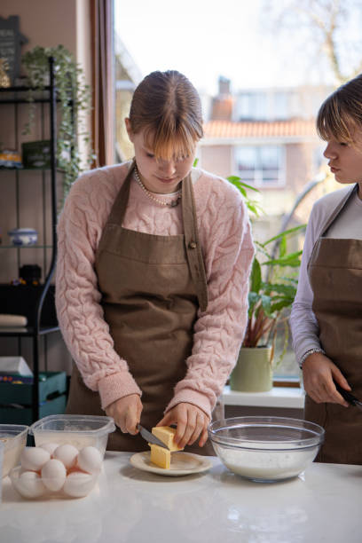istock Two blonde teenage sisters making a cake 2197845627