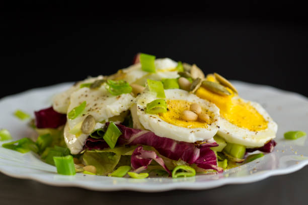 istock Salad with seeds and vegetables in a plate, isolated on a black background 2197846848